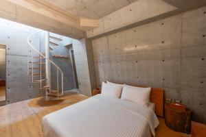 ein Schlafzimmer mit einem Bett und einer Wendeltreppe in der Unterkunft Mao House in Tainan + 53 Fotos