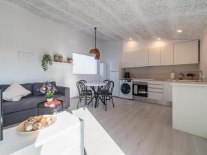 a living room and kitchen with a couch and a table at Winahost Pla de Can Sans in Sant Andreu de Llavaneres