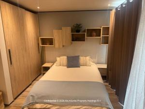 a bedroom with a large bed and wooden cabinets at studio to Maho in Cupecoy +10 photos