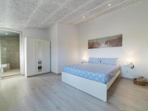 a white bedroom with a bed and a bathroom at Winahost Pla de Can Sans in Sant Andreu de Llavaneres