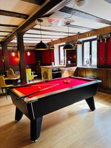 a billiard table in a room with a red pool at Logis Hôtel-Restaurant Aux Trois Roses in La Petite-Pierre