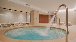 a hot tub with a water fountain in a room at htop Jadhe SPA 4Sup - Bliss in Calella