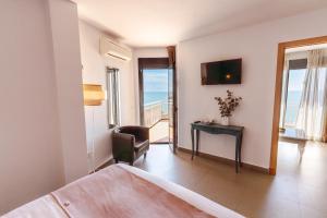 a bedroom with a bed and a desk and a television at Hotel Mainare Playa in Fuengirola