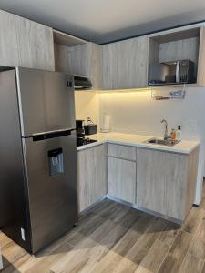 a kitchen with a refrigerator and a sink at studio to Maho in Cupecoy