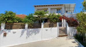a white house with a fence in front of it at Theo Two-Bedroom Apartment in Marathias