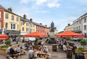 a group of people sitting at tables on a city street at The Fig Tree in Brecon