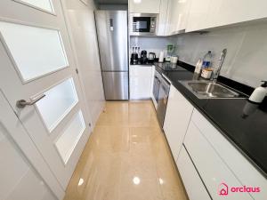 a white kitchen with a door and a sink at Sun & Sea in Cabanes