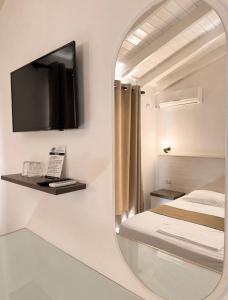 a bedroom with a mirror and a bed and a tv at Mariksel HOTEL in Ksamil +60 photos