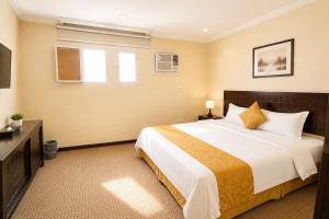 a bedroom with a large bed and a television at سويت tolan in Hail