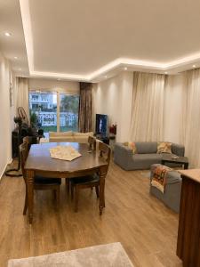 a living room with a table and a couch at Luxury Seaside Villa Direct Pool Access, Private Garden & Rooftop Stella Heights Sidi Abdelrahman فيلا مميزه جدا في الساحل الشمالي ستيلا هايتس سيدي عبدالرحمن in El Alamein