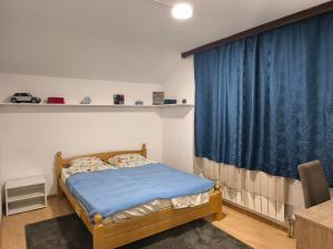 a bedroom with a bed and a blue curtain at Hideout Guest House in Travnik +15 photos