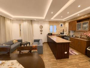a kitchen and living room with a couch and a table at Luxury Seaside Villa Direct Pool Access, Private Garden & Rooftop Stella Heights Sidi Abdelrahman فيلا مميزه جدا في الساحل الشمالي ستيلا هايتس سيدي عبدالرحمن in El Alamein