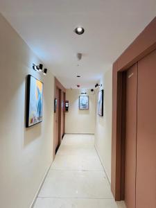 a long hallway with paintings on the walls at Hotel Pacific Empire in Ahmedabad +7 photos