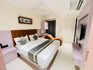 a hotel room with a bed and a television at Hotel Pacific Empire in Ahmedabad