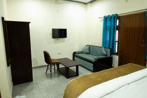 a bedroom with a bed and a chair and a couch at The Ushmaya Lifestyle Wellness Resort Near Rishikesh in Haridwār