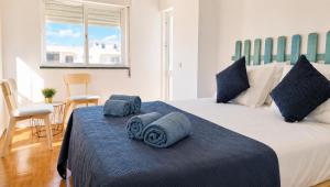 a bedroom with a bed with towels on it at Maré Viva in Quarteira