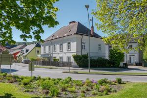 a white house with a black roof on a street at Alte Schule Reichenau an der Rax in Reichenau