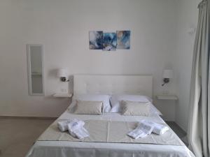 a white bedroom with a bed with towels on it at Venti Magici Rooms in Peschici