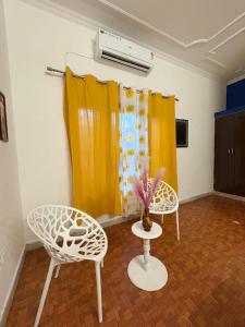a room with two chairs and a vase on a table at The pink villa in Jaipur +6 photos