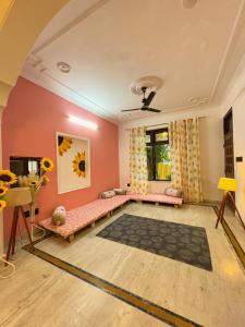 a living room with pink walls and a room with a couch at The pink villa in Jaipur