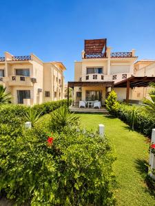 an exterior view of a building with a yard at Luxury Seaside Villa Direct Pool Access, Private Garden & Rooftop Stella Heights Sidi Abdelrahman فيلا مميزه جدا في الساحل الشمالي ستيلا هايتس سيدي عبدالرحمن in El Alamein