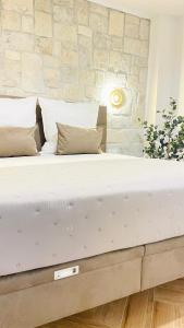 a large bed in a bedroom with a stone wall at Stonehouse-Pag in Povljana