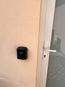 an open door with a black alarm clock on it at Penzion Lederer in Dolní Dunajovice