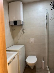 a small bathroom with a toilet and a shower at Sunrise apartmani in Bar +35 photos