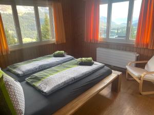 two twin beds in a room with windows at Chalet Casa Cresta - Top of Lenzerheide - bis 9 Personen in Valbella