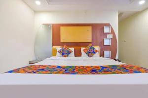 a bedroom with a large bed with a colorful bedspread at FabHotel Jaipur Classic - Vaishali Nagar in Jāmb +26 photos