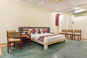 a bedroom with a bed and a table and chairs at FabHotel Jaipur Classic - Vaishali Nagar in Jāmb