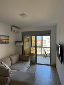 a living room with a couch and a sliding glass door at Sunrise apartmani in Bar