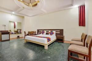 a bedroom with a bed and a couch and a chair at FabHotel Jaipur Classic - Vaishali Nagar in Jāmb