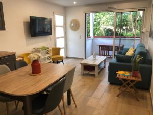 a living room with a table and a couch at Villa Bambous 1 et 2 in Hossegor
