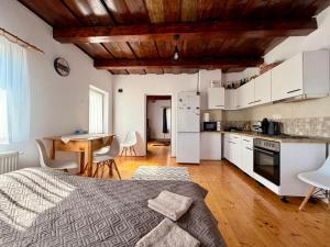 a bedroom with a bed and a kitchen with a table at Medelore Cottage in Medişoru Mare