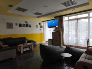 a living room with couches and a flat screen tv at Hideout Guest House in Travnik