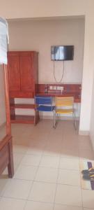 a room with two chairs and a table and a tv at The Folks Inn in Mombasa