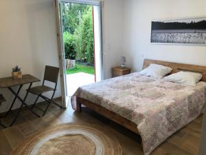a bedroom with a bed and a table and a chair at Villa Bambous 1 et 2 in Hossegor