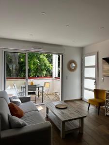 a living room with a couch and a table at Villa Bambous 1 et 2 in Hossegor