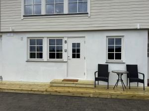 two chairs and a table in front of a house at Smart mini apartment with kitchen in Åmot