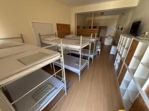 a room with several bunk beds and a kitchen at Garden Hostel in Aradas +89 photos