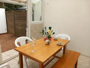 a wooden table with chairs and a vase of flowers on it at La Petite de Cayola in Talmont +11 photos