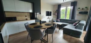 a living room with a table and a couch at Mazury Home Apartament in Giżycko