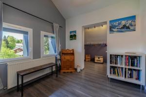 a room with a bench and a book shelf at Au doux passage in Les Rousses