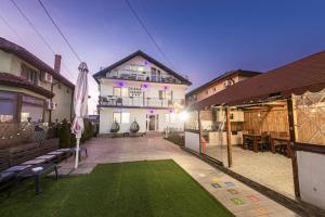 a house with a lawn in front of a building at Pensiunea Gerard 2 Mai Camere Moderne cu baie privata, la 250 M de plaja ,Foisor, Parcare & WIfi Gratuit in 2 Mai