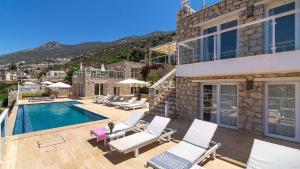 a villa with a swimming pool and white chairs at TEKCE Villa Dolly N24 in Kalkan