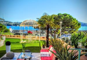 ヴィルフランシュ・シュル・メールにあるDeluxe apartment Villefranche Sea view front Terrace 230m2 with Jacuzziのガゼボ、テーブル、椅子付きの庭園