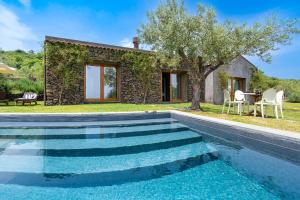a villa with a swimming pool in front of a house at Monaci delle Terre Nere in Zafferana Etnea