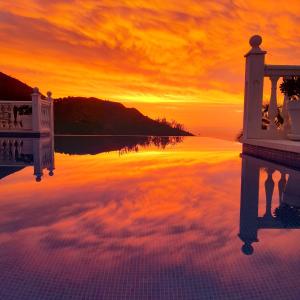 a sunset over a body of water with the sky at Villa Mañana in Mijas