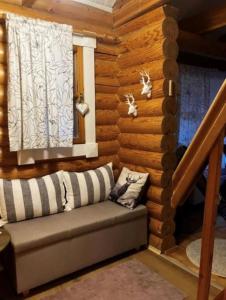 a room with a couch in a wooden wall at Honkahimos 7, Pohjois-Huippu, Jämsä in Jämsä +16 photos